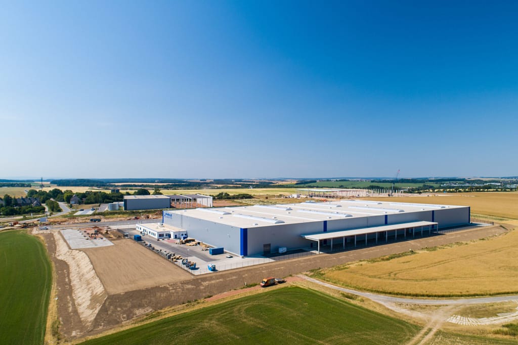 Gran nave industrial junto a campos vista desde el aire