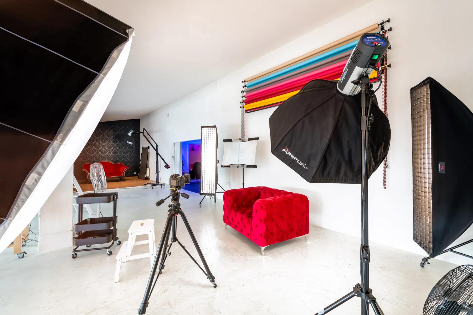 NEWPIC Studio Dresden mit Blitztechnik, Lichtformern, Hintergrundrollen und rotem Sofa